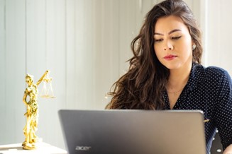 woman researching the end to forced arbitration on laptop 